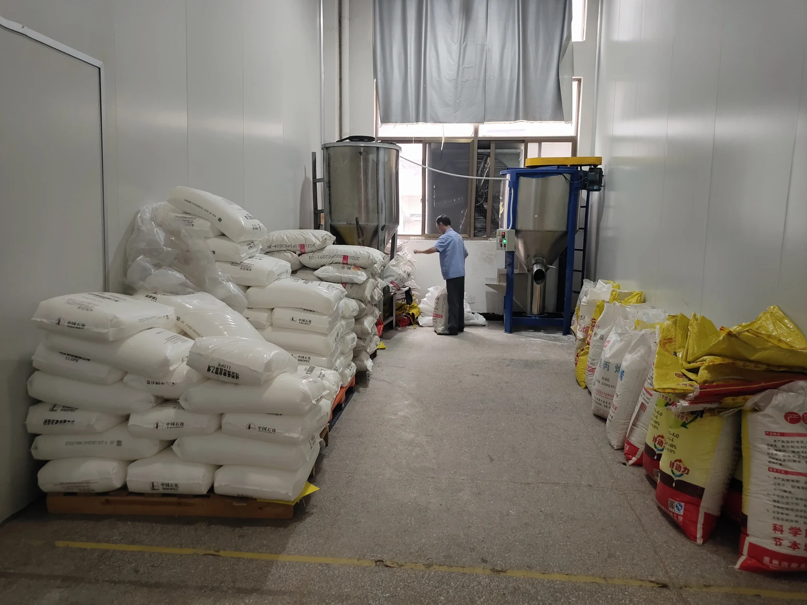Supplier-provided archive photograph of bagged raw materials and mixing equipment